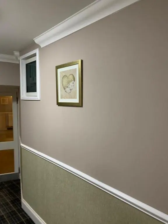 a hallway with a white wall with a picture on it at Royal Hotel in Dingwall