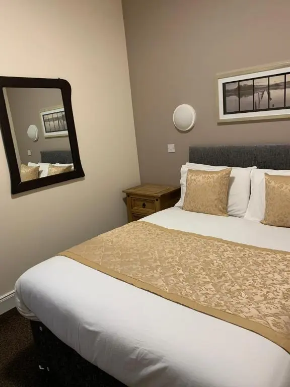 a hotel room with a bed and a mirror at Royal Hotel in Dingwall