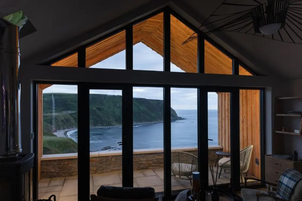 a room with a view of the ocean from a house at Muckle View in Gardenstown