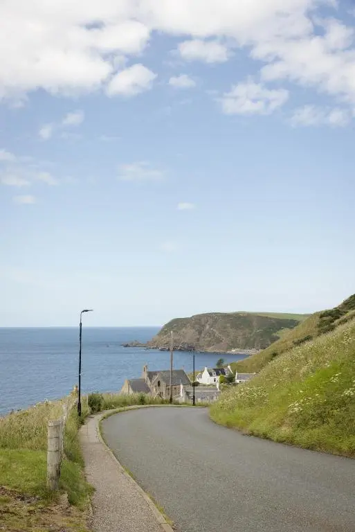 a winding road next to a body of water at Muckle View in Gardenstown