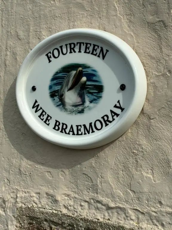 a sign on a wall with a duck in the water at Wee Braemoray, Portessie, Buckie,Moray in Portessie