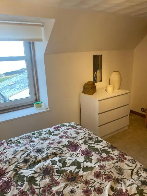 a bedroom with a bed and a window at Wee Braemoray, Portessie, Buckie,Moray in Portessie