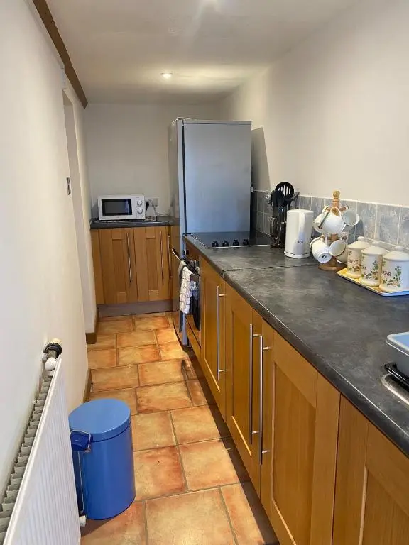 a kitchen with wooden cabinets and a stainless steel refrigerator at Wee Braemoray, Portessie, Buckie,Moray in Portessie