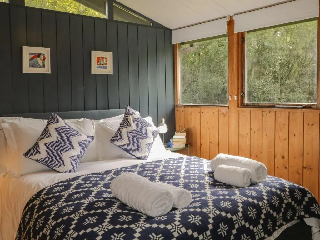 a bedroom with a bed with two towels on it at Blue Pine Lodge in Dornoch