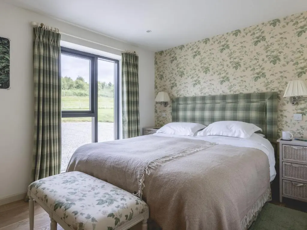 a bedroom with a large bed and a window at Phils House in Lairg
