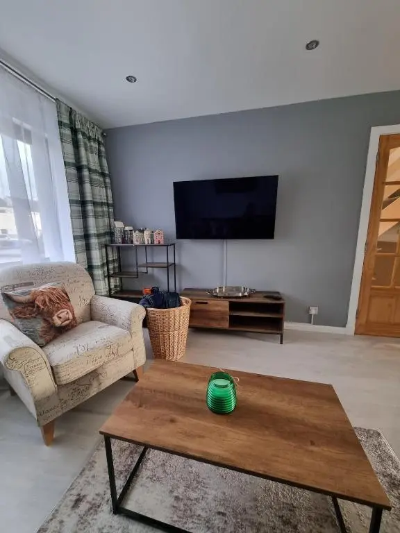 a living room with a couch and a coffee table at Highland Breeze Inverness in Inverness