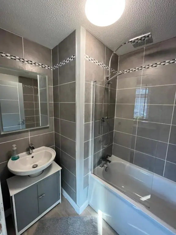 a bathroom with a sink and a tub and a mirror at 24 Two bedroom apartment Culloden Inverness Highlands in Culloden