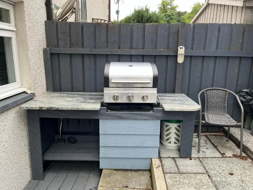 a grill on a deck next to a fence at 24 Two bedroom apartment Culloden Inverness Highlands in Culloden