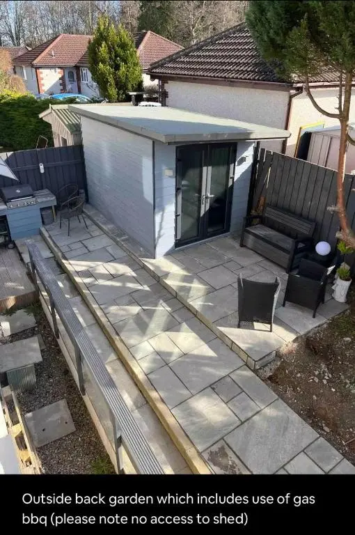 a backyard patio with a bench and a house at 24 Two bedroom apartment Culloden Inverness Highlands in Culloden