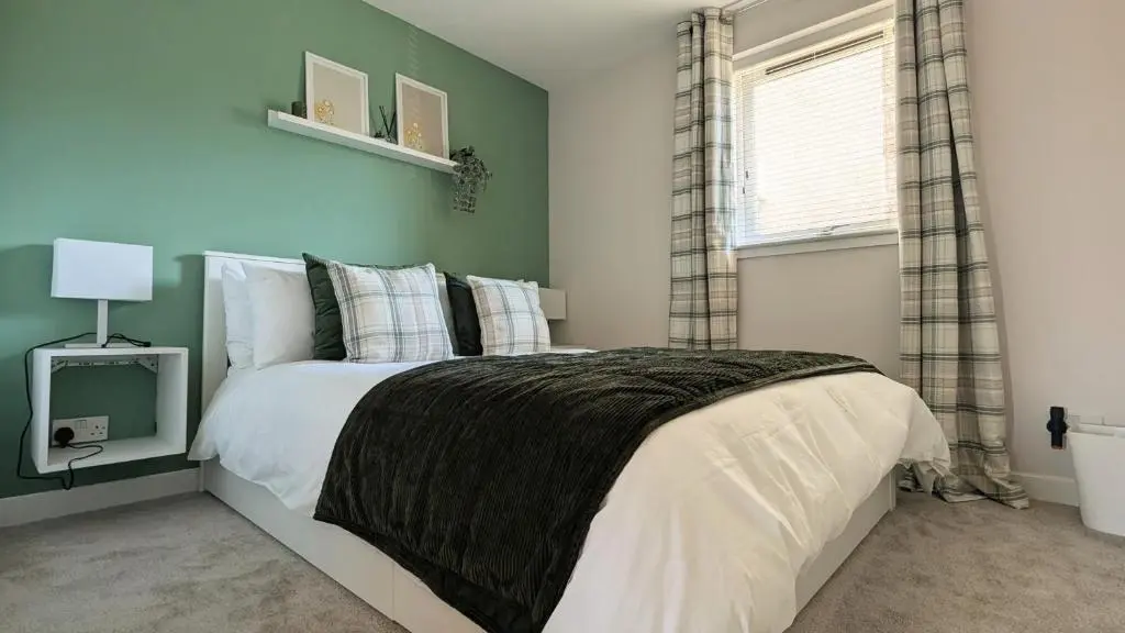 a bedroom with a bed and a television in it at The Wee Heilan' Drochaid in Inverness