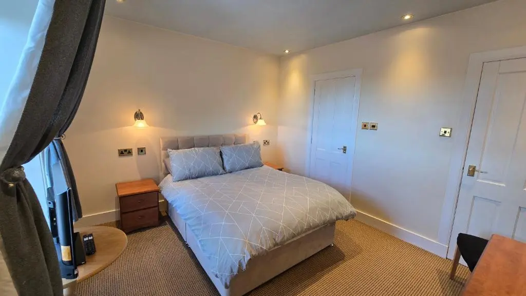 a bedroom with a bed and a television in it at The Pitfour Arms Hotel in Mintlaw