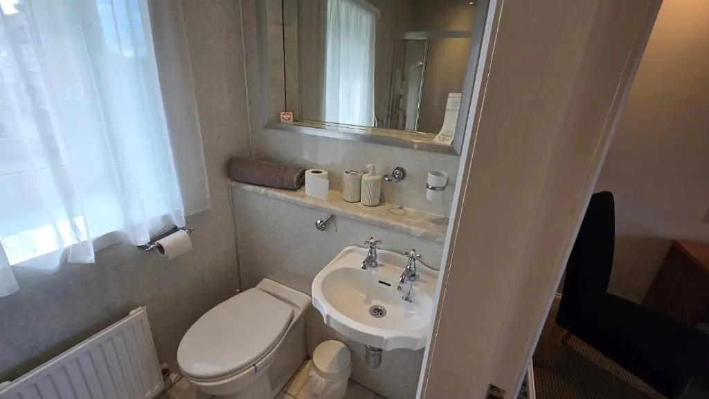 a small bathroom with a toilet and a sink at The Pitfour Arms Hotel in Mintlaw