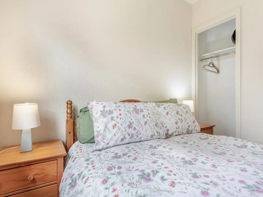 a bedroom with a bed and a lamp and a window at Tanera in Wick