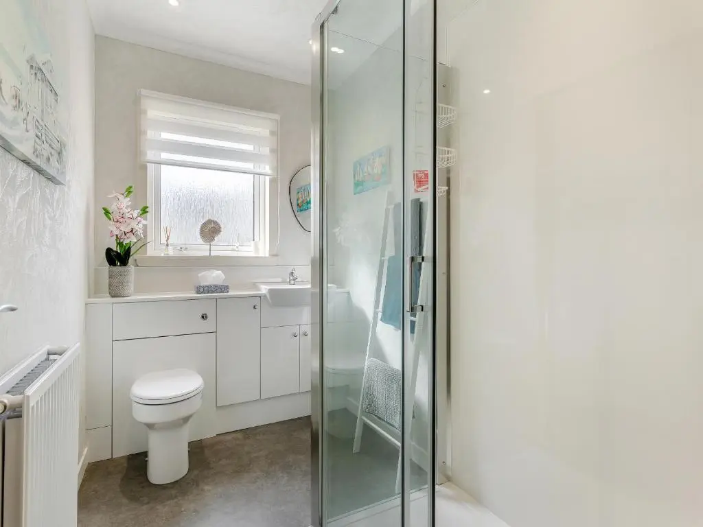 a bathroom with a toilet and a glass shower at Tanera in Wick