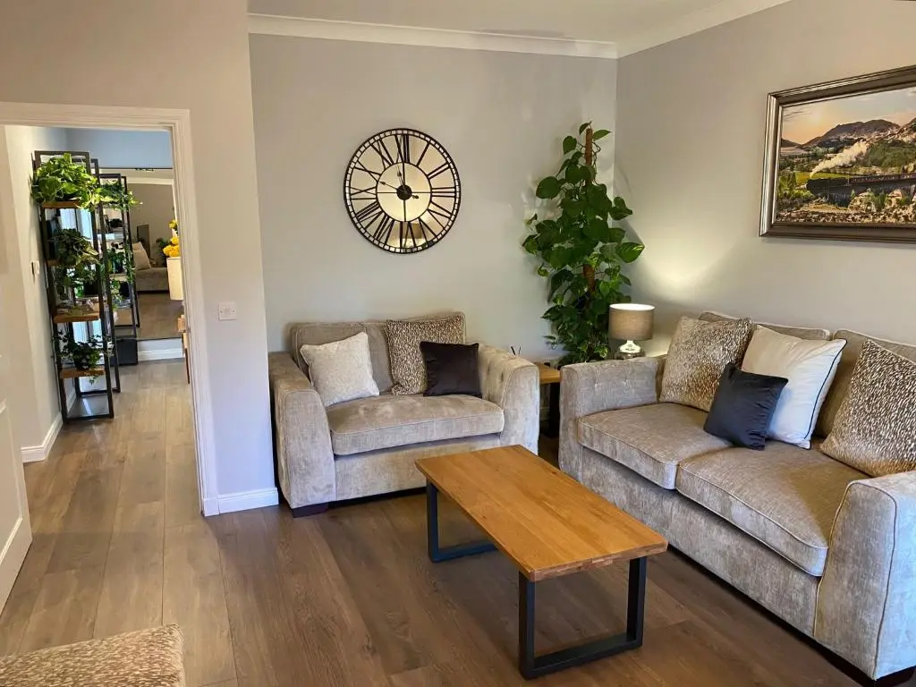 a living room with two couches and a table at travelNess Apartment in Inverness