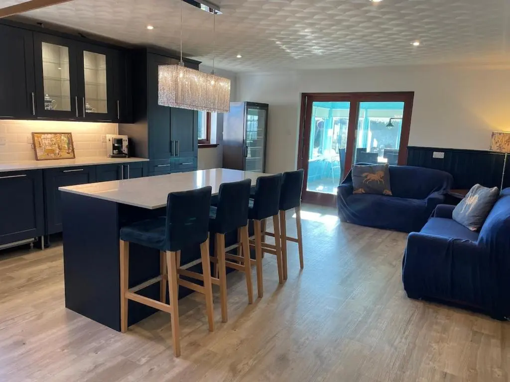 a kitchen with a table and chairs and a couch at Abalone Accommodation in Culbokie
