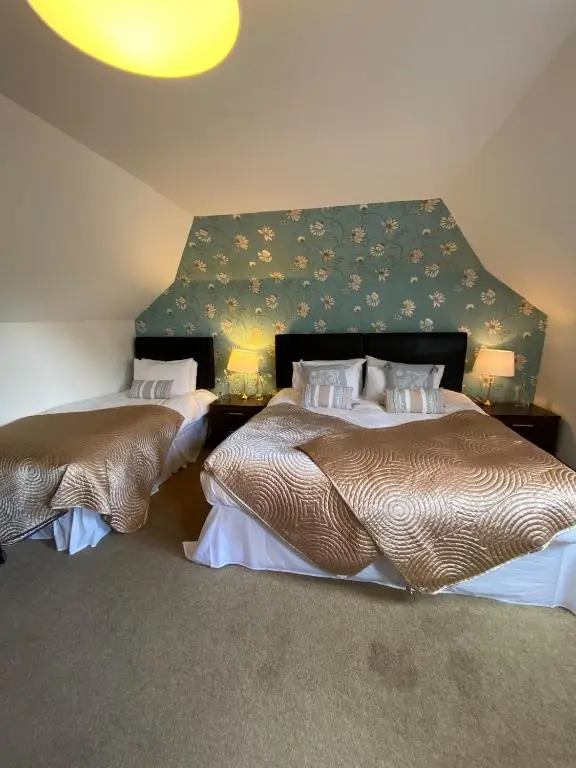 two beds in a room with a wall at Abalone Accommodation in Culbokie
