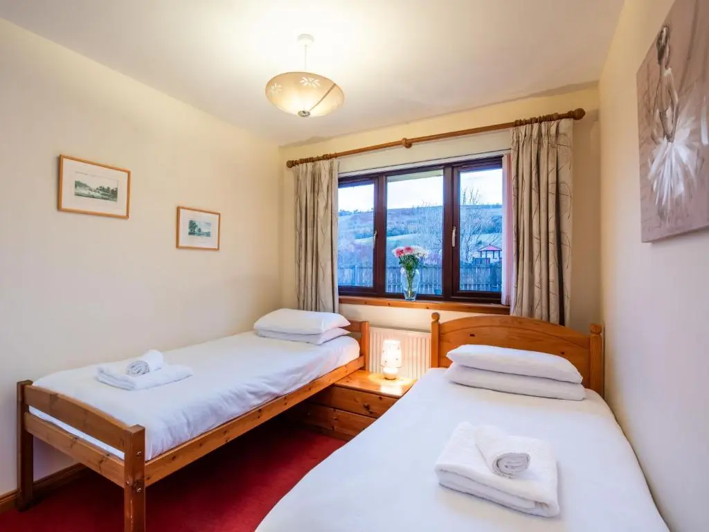 two beds in a room with a window at Holiday Home Coiltie House by Interhome in Drumnadrochit