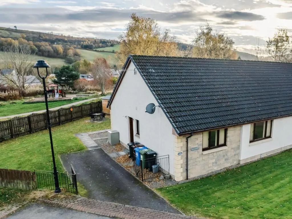 a small white house with a black roof at Holiday Home Coiltie House by Interhome in Drumnadrochit