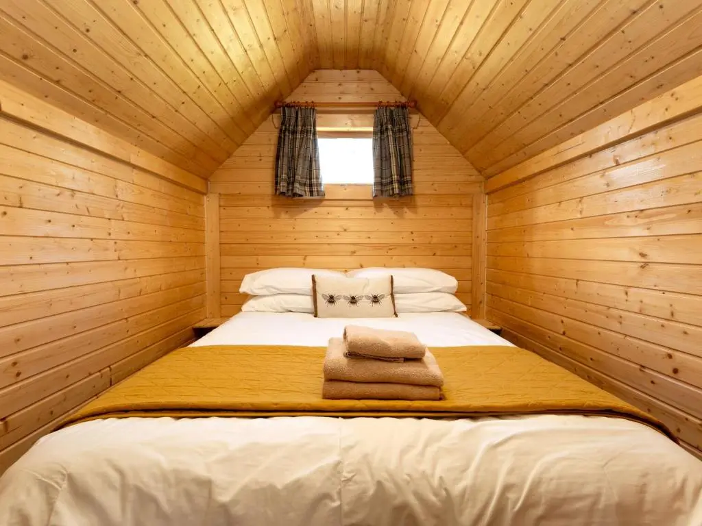 a bedroom with a bed in a wooden cabin at Apartment Birch Bothy by Interhome in Coldstone
