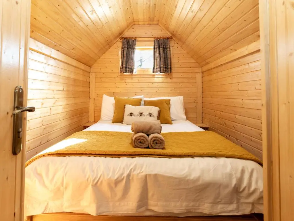 a bedroom with a bed in a wooden cabin at Apartment Hazel Bothy by Interhome in Coldstone