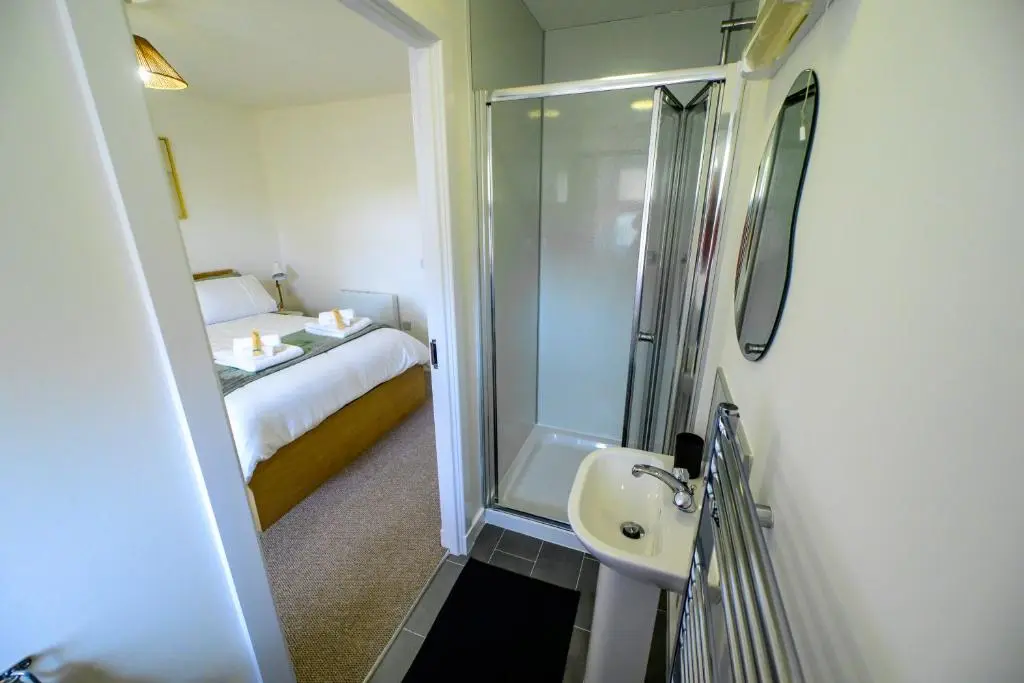 a bathroom with a shower and a sink and a bed at 2 Bed Property, Beauly in Beauly