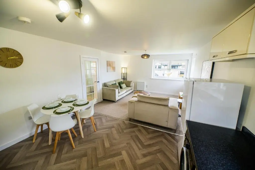 a kitchen and living room with a table and chairs at 2 Bed Property, Beauly in Beauly