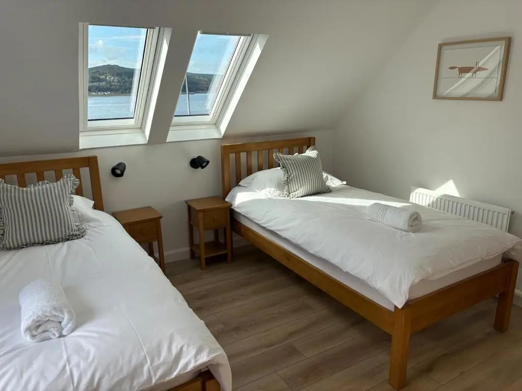 two beds in a room with two windows at Seaside Retreat - Quiet Seafront Spot with Free Parking in North Kessock