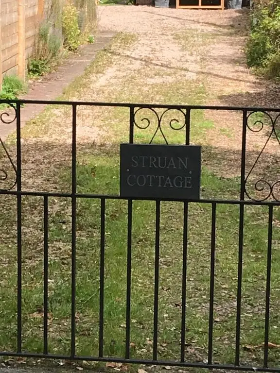 a sign on a iron gate in front of a driveway at Struan Cottage in Ballater