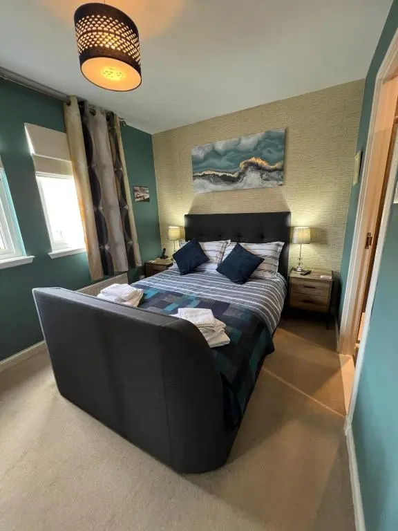 a bedroom with a bed with a couch in it at Lighthouse Cottage Cullen in Cullen