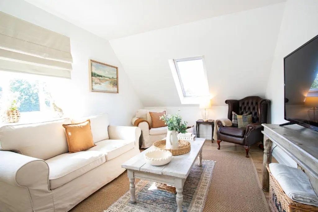 a living room with white furniture and a flat screen tv at Lillymont Apartment - Inverness City Centre in Inverness