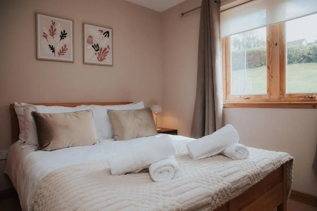 a bedroom with a bed with towels on it at Spacious Flat with Parking Great Inverness Base in Inverness