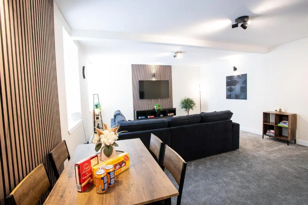 a living room with a couch and a table at Baron Taylor Stays in Inverness