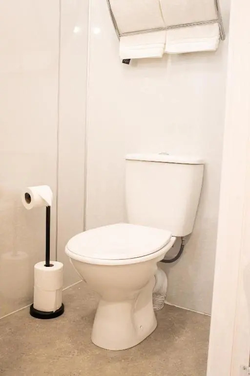 a white toilet in a bathroom with a roll of toilet paper at Baron Taylor Stays in Inverness