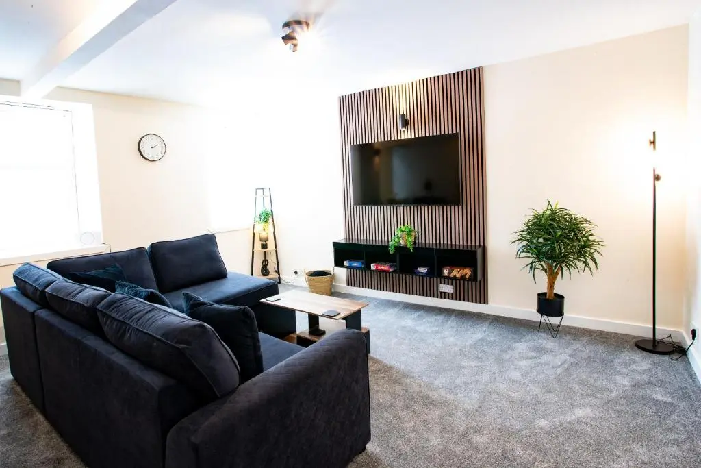 a living room with a couch and a tv at Baron Taylor Stays in Inverness