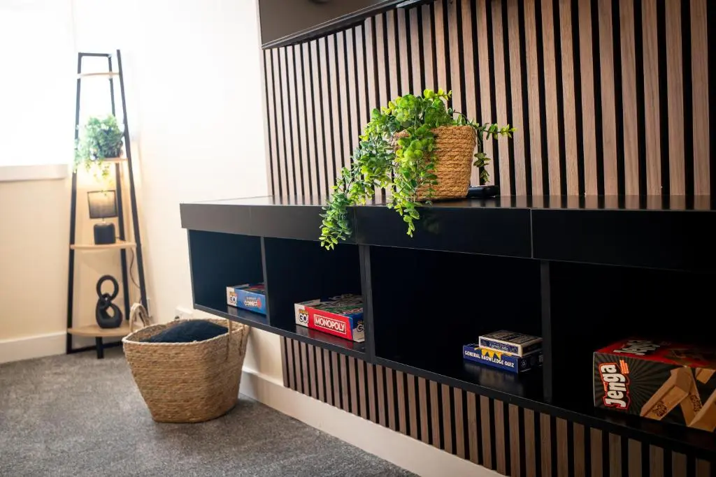 a black shelf with plants on it in a room at Baron Taylor Stays in Inverness