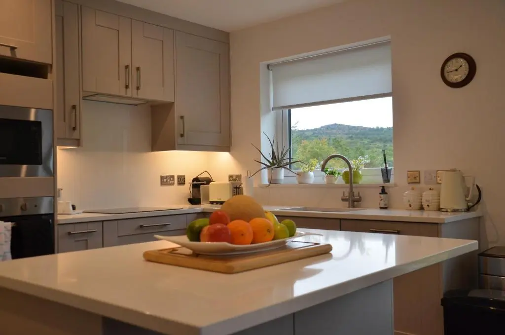 a kitchen with a bowl of fruit on a counter at Fionnlagh Cottage in Eskadale