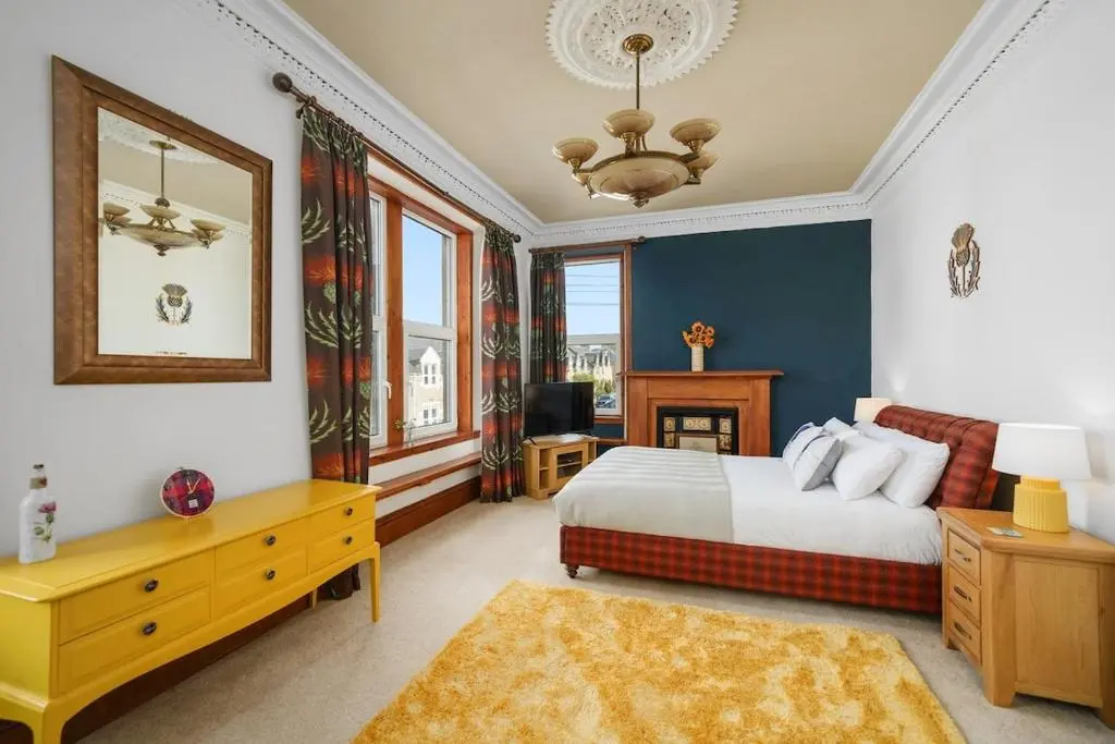 a bedroom with a king sized bed and a mirror at Crown Jewel - Inverness City Centre in Inverness