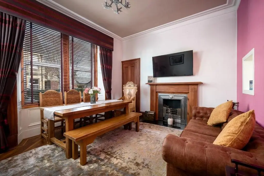 a living room with a table and a fireplace at Crown Jewel - Inverness City Centre in Inverness