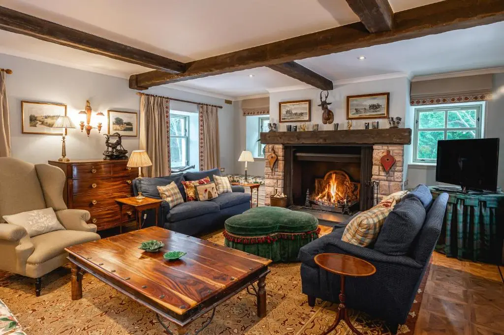 a living room filled with furniture and a fireplace at Grieves Cottage Balnagown Estate in Kildary