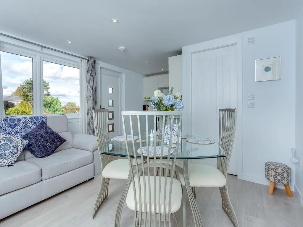 a living room with a glass table and chairs at Charlies Cottage in Inverness