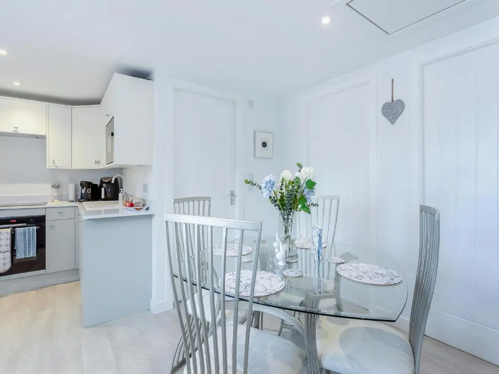 a dining room with a glass table and chairs at Charlies Cottage in Inverness
