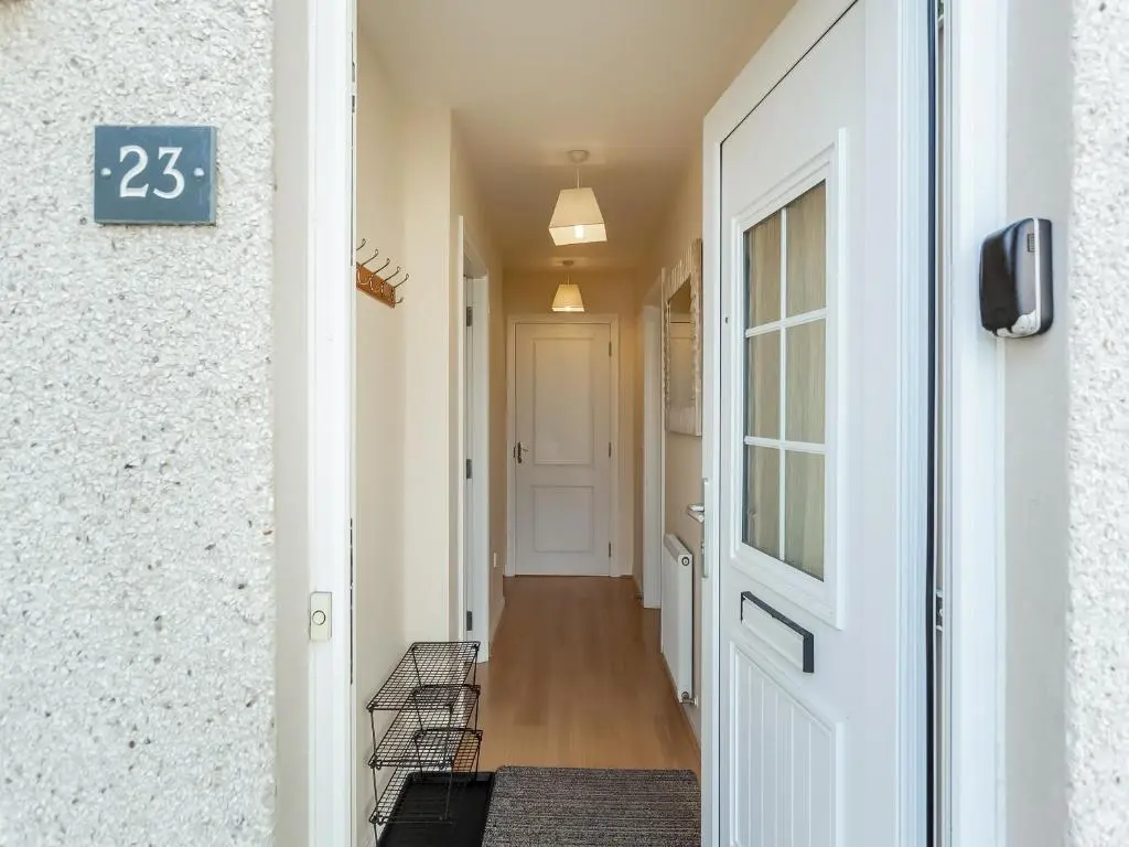 a hallway with a door and a sign on a wall at Kincraig Apartment in Inverness