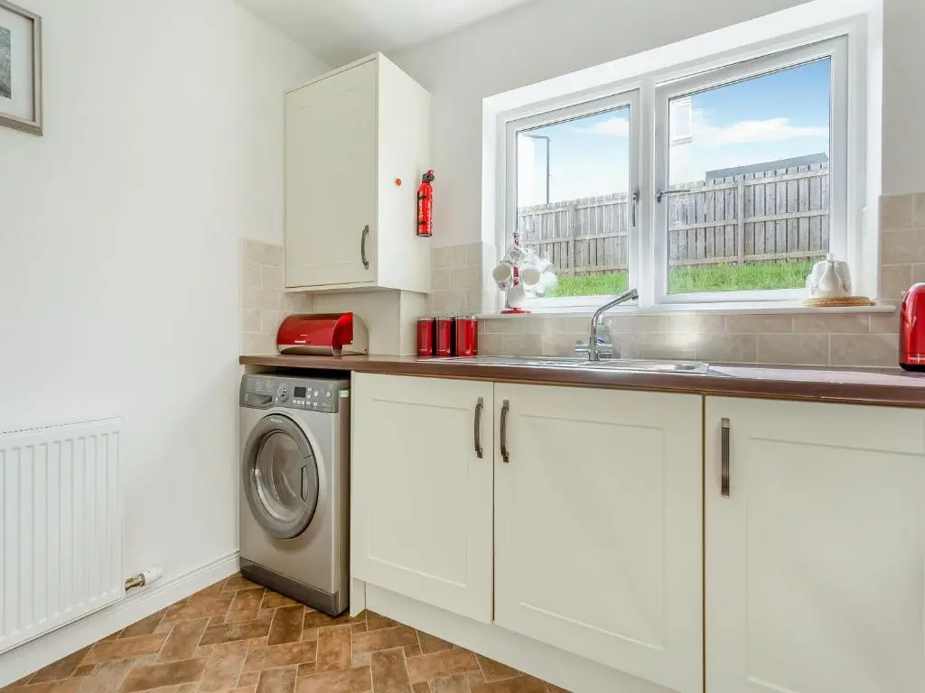a kitchen with a sink and a washing machine at Kincraig Apartment in Inverness