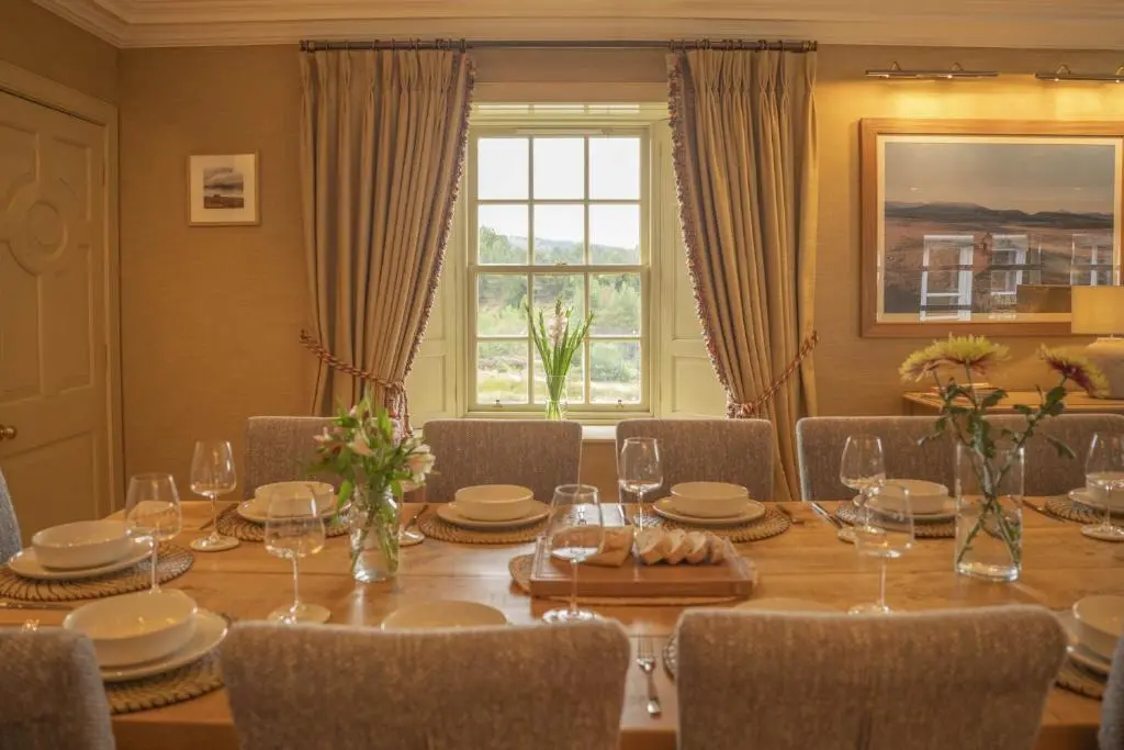 a dining room with a table and chairs and a window at Drum Lodge in Nethy Bridge