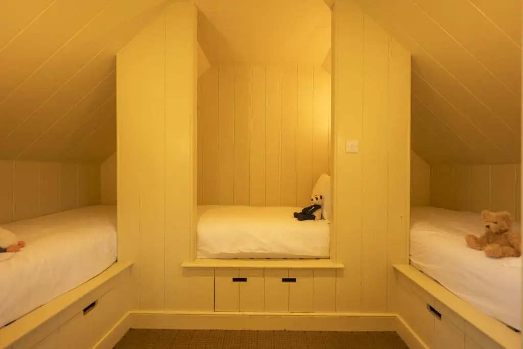 a room with two beds and a teddy bear at Drum Lodge in Nethy Bridge