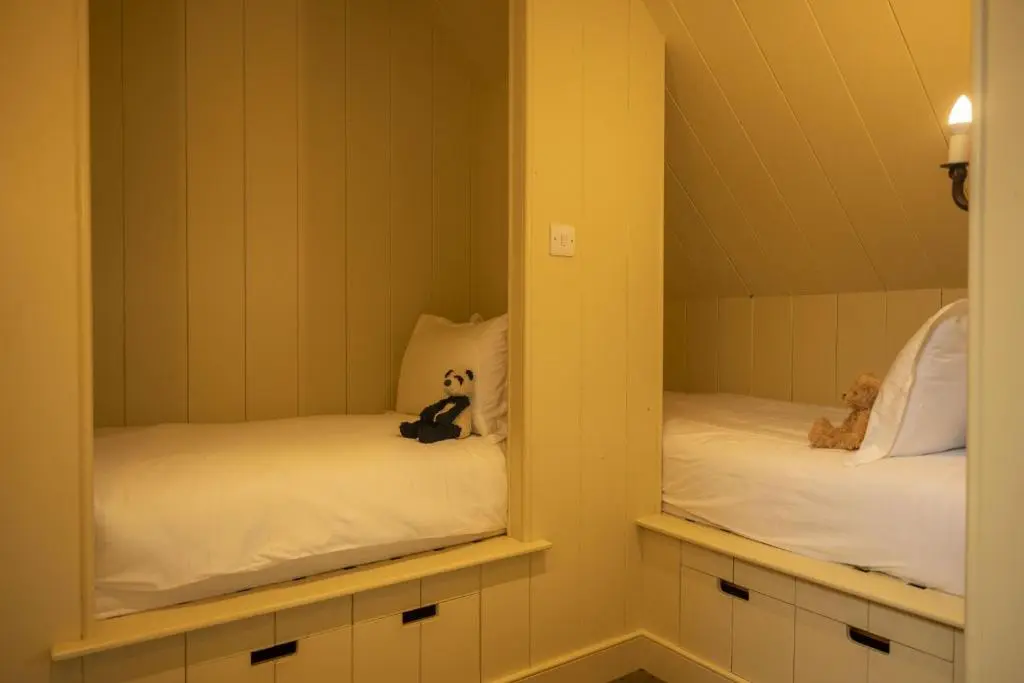 two beds in a room with two mirrors at Drum Lodge in Nethy Bridge