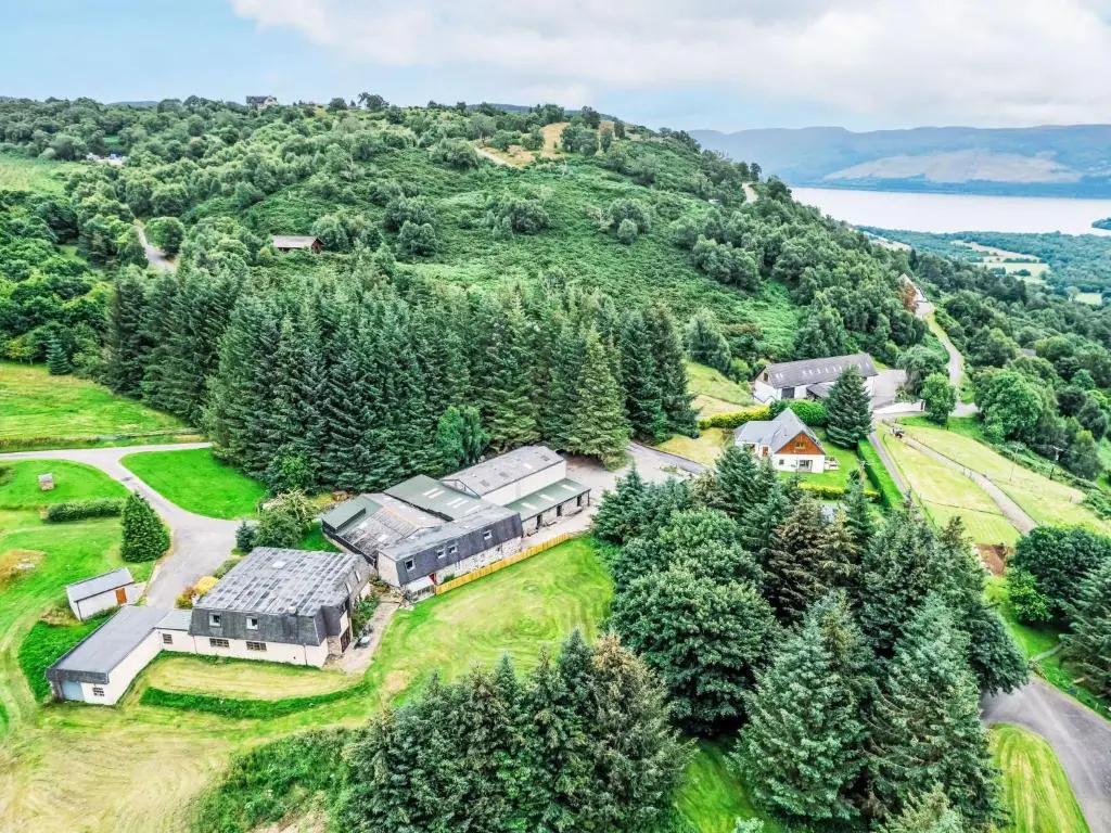 an aerial view of a house on a hill with trees at Holiday Home Highland Garden Room by Interhome in Drumnadrochit