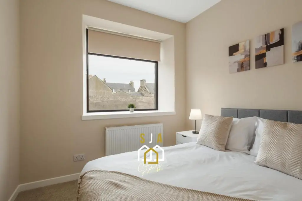 a bedroom with a white bed with a window at Fraserburgh Residence - SJA Stays - Modern 3 Bed Apartment in Fraserburgh