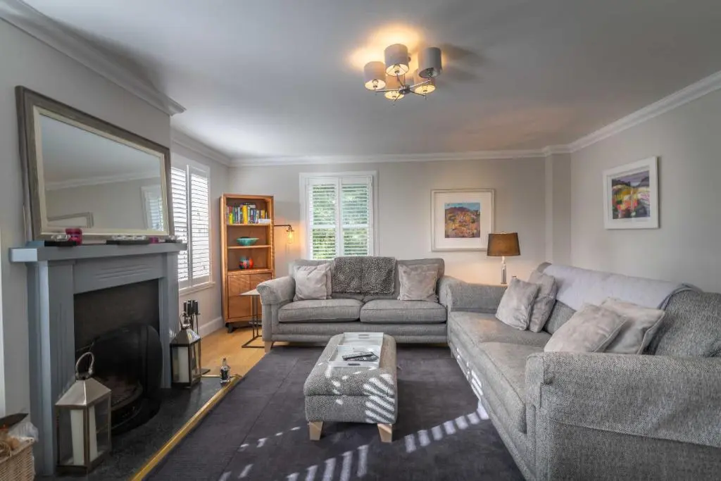 a living room with a couch and a fireplace at Glen Tilt House in Bridge of Tilt